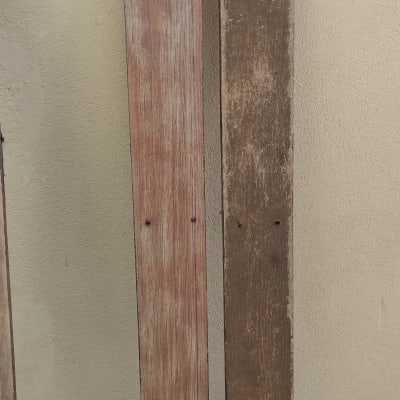 שתי קרשים מעץ עם חורים על רקע קיר