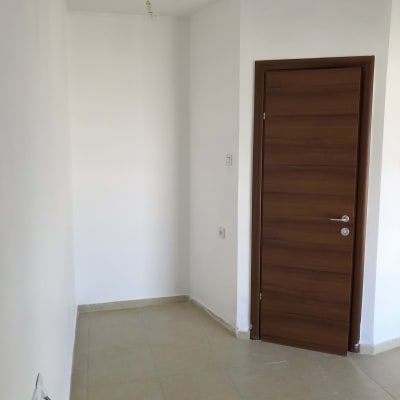 קיר צבוע בלבן עם דלת עץ חומה