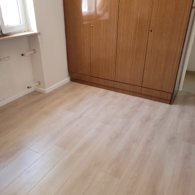 רצפת פרקט עץ בהירה בחדר עם ארון עץ.