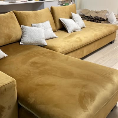 ספה מרופדת בצבע חום עם כריות לבנות