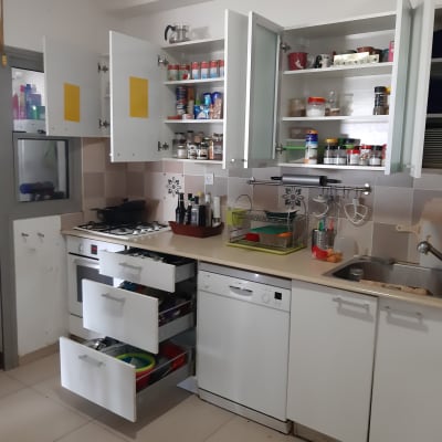 מטבח עם ארונות פתוחים, מדפים עם תבלינים, כלים בכיור