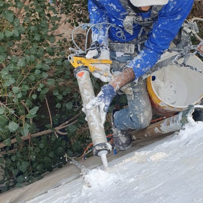 אדם עם קסדה ורובה איטום על גג