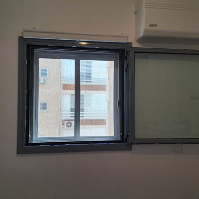 חלון אלומיניום עם מסגרת כהה ותריסים