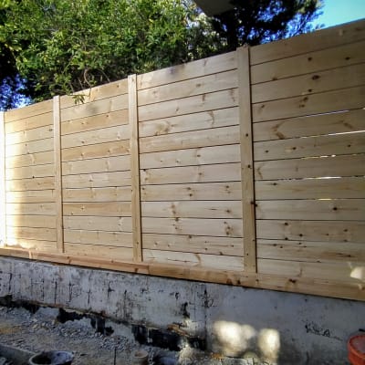 גדר עץ חדשה מותקנת בגינה עם קרקע חשופה