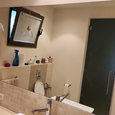 מנורת זכוכית תלויה מעל כיור בחדר אמבטיה