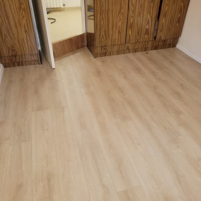 רצפת פרקט עץ בהירה בחדר עם ארון עץ