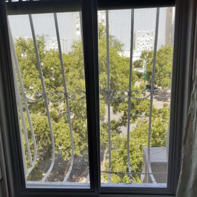 חלון אלומיניום עם סורגי מתכת נראים מבחוץ