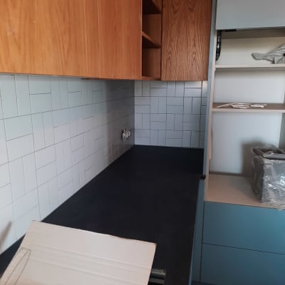 שיש שחור, ארונות עץ, קיר אריחים לבנים