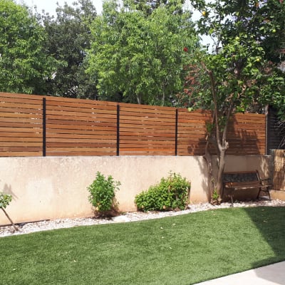 גדר עץ חומה עם עמודי מתכת בגינה