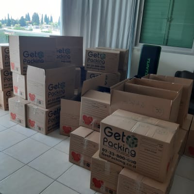 קופסאות קרטון של Get Packing מסודרות בחדר