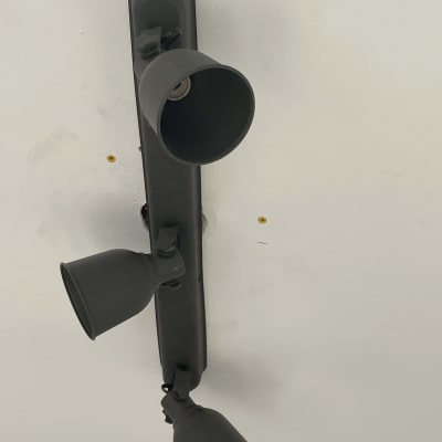 גוף תאורה שחור עם שלושה פנסים על תקרה לבנה