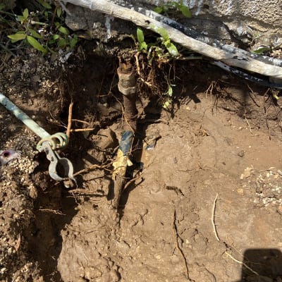 צינור מים חשוף באדמה עם חיבורים