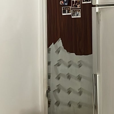 דלת עם ציפוי מתקלף ותמונות מודבקות