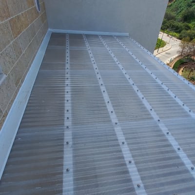 גג פלסטיק שקוף עם ברגים לאורך קירות אבן