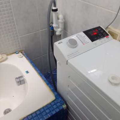 מכונת כביסה עם צינור ניקוז מחובר לקיר