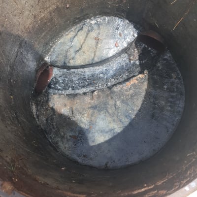 פתח ביוב עם צינורות מתכת וחלודה