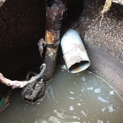 צינור חלוד עם חור, מים עומדים