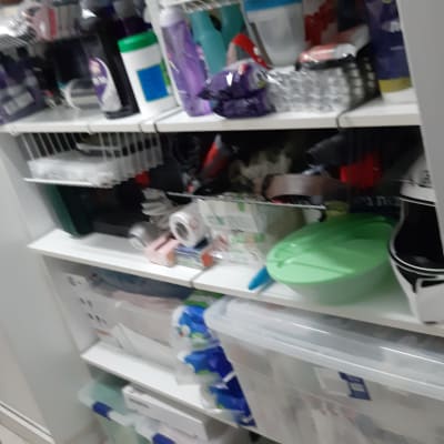 מדפים עם מוצרי ניקוי, קופסאות פלסטיק ומכסים