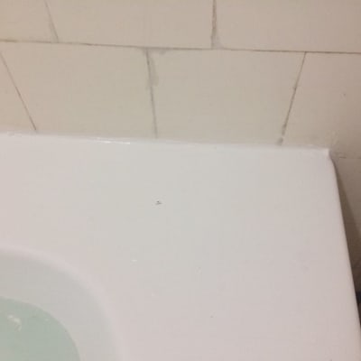 חיבור בין אמבטיה לקיר עם אריחים לבנים