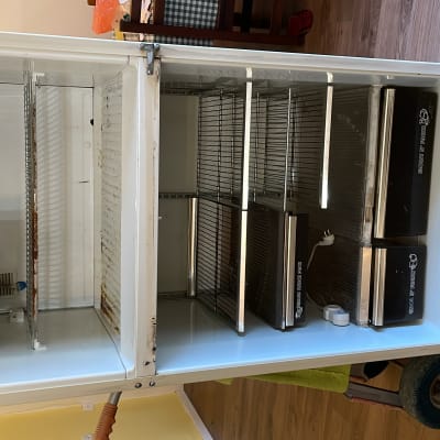 מקרר פתוח עם מדפים ריקים וכלי עבודה בצד