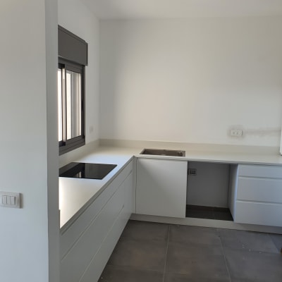 משטח שיש לבן במטבח מודרני עם כיור וכיריים