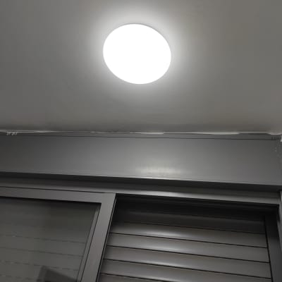 תאורה עגולה על תקרה מעל חלון עם תריסים