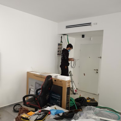 חשמלאי עובד עם כבלים ולוח חשמל