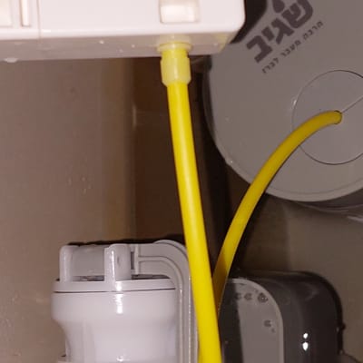 צינור צהוב מחובר למערכת אינסטלציה לבנה