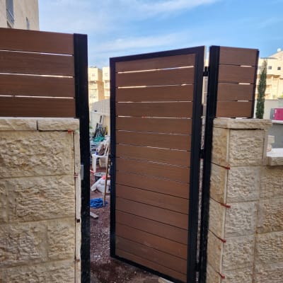 שער עץ פתוח עם מסגרת מתכת שחורה