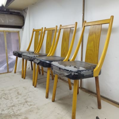 כיסאות עץ עם ריפוד קרוע בתהליך תיקון