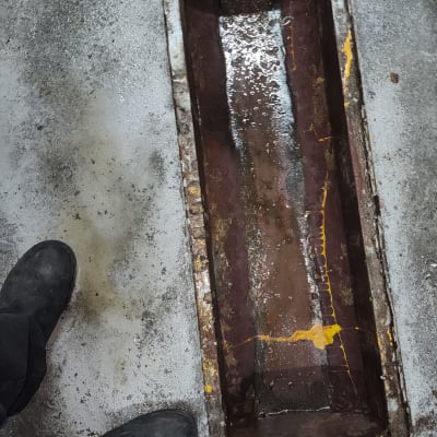 תעלת ניקוז פתוחה עם מים על רצפת בטון