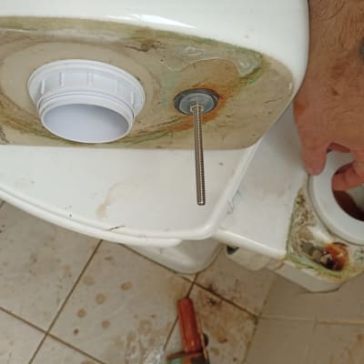 יד מתקנת אסלה עם ברגים וחלקי צנרת