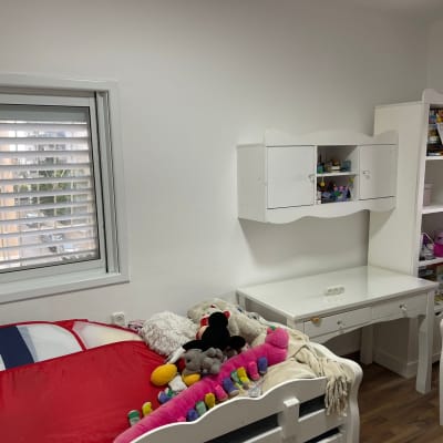 חדר ילדים עם מיטות, שולחן וצעצועים