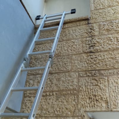 סולם מתכת ליד קיר אבן עם פתח לאטימה