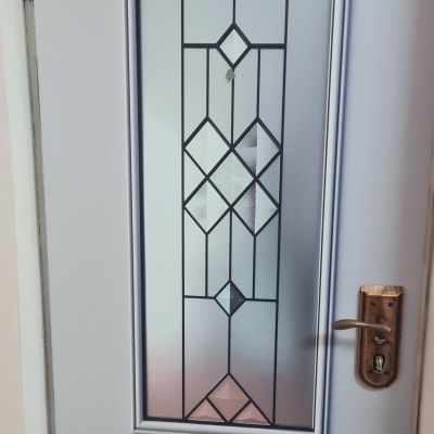 דלת עם ציפוי זכוכית ודוגמת מתכת גיאומטרית