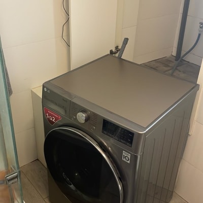 מכונת כביסה אפורה בחדר אמבטיה קטן