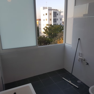 חדר אמבטיה עם רצפה כהה וכלים סניטריים מותקנים