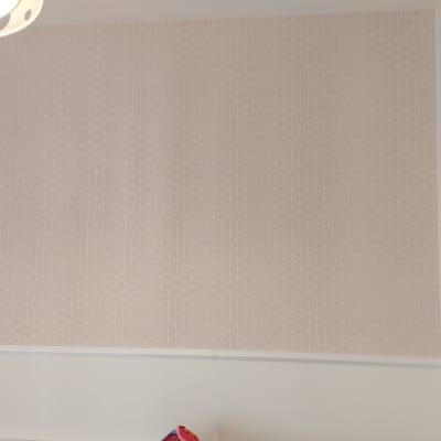 טפט גיאומטרי בצבע ורוד בהיר על קיר