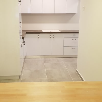 מטבח חדש עם ארונות לבנים ומשטח עבודה אפור