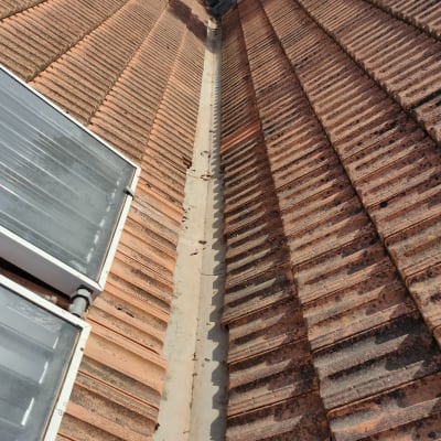 רעפים חומים על גג עם תעלת ניקוז במרכז