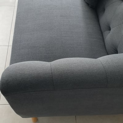 ספה אפורה עם כריות על רצפה בהירה