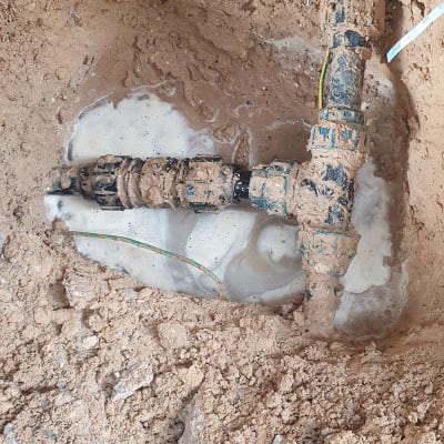 צינור מים עם חיבורים באדמה רטובה