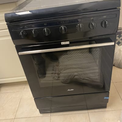 תנור גז שחור עם חמישה כפתורים עליונים