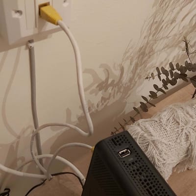 כבל רשת מחובר לשקע קיר ולנתב אינטרנט