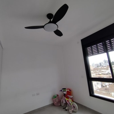 מאוורר תקרה שחור מותקן בחדר לבן