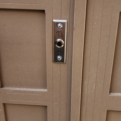 לחצן אינטרקום על דלת מתכת חומה
