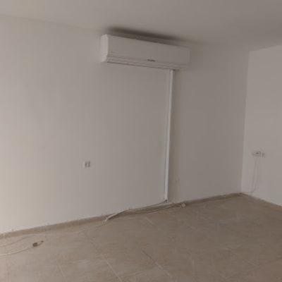 חדר עם קירות צבועים בלבן ומזגן מותקן