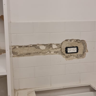 שקע חשמל כפול בקיר עם טיח חשוף