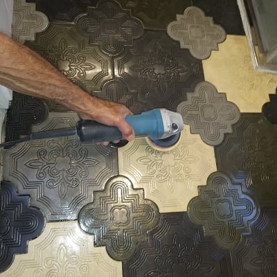 יד מחזיקה מכונת פוליש על רצפה מעוצבת