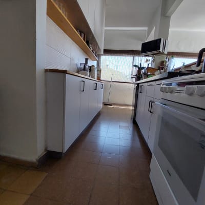 מטבח עם ארונות לבנים, תנור ומיקרוגל